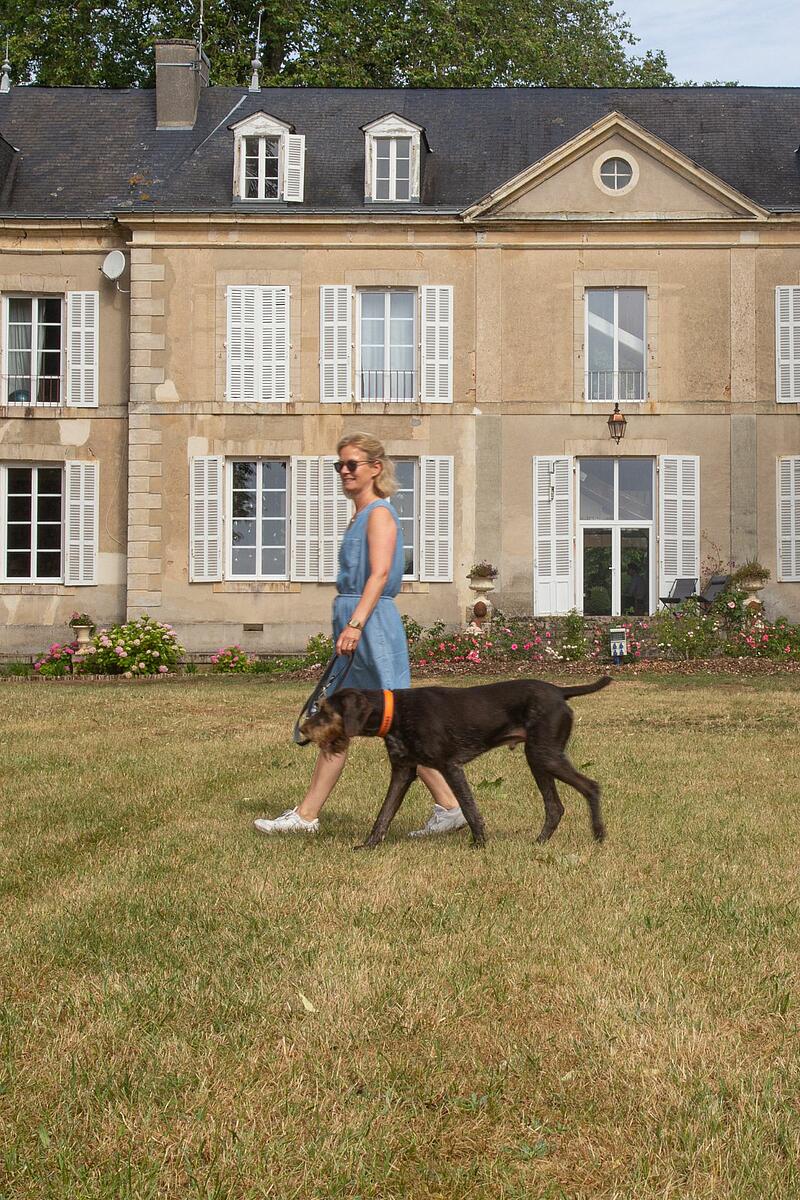 Femme promenant un chien devant le château de Chanteloup façade du château de Chanteloup, avec une femme promenant son chien